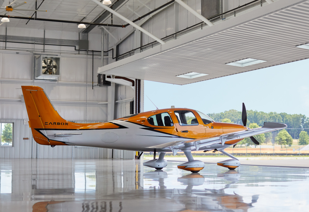 private aircraft sitting in hangar with door open