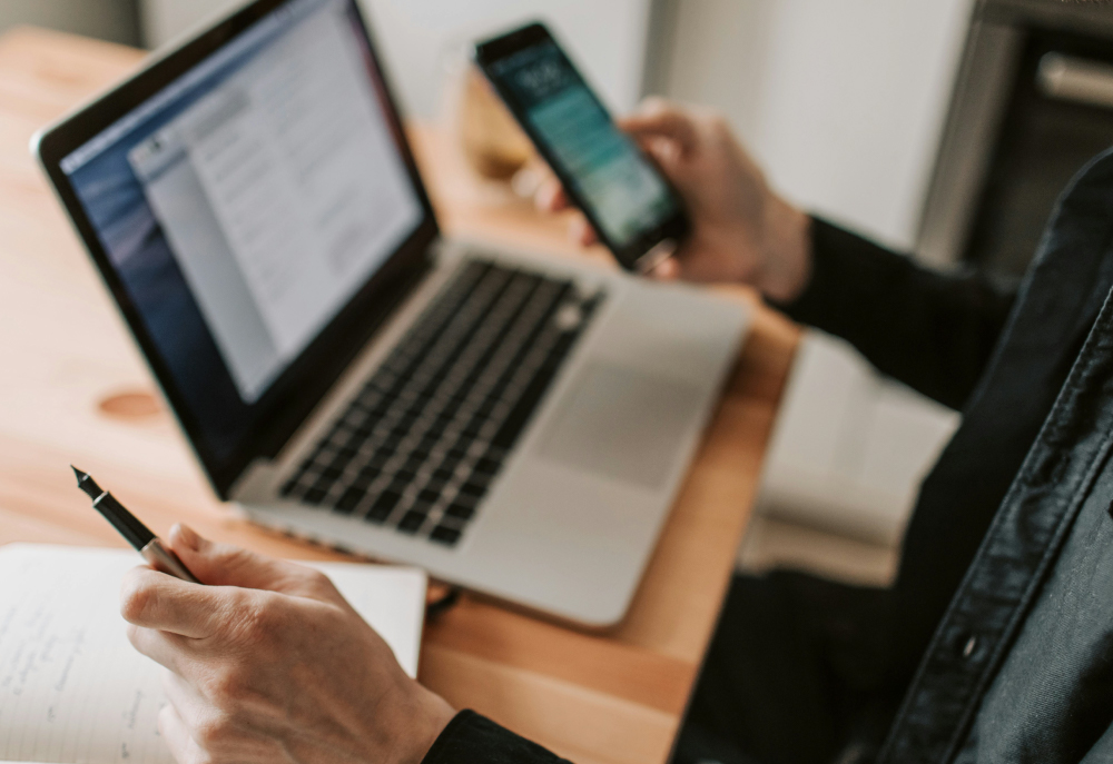 man using phone and laptop