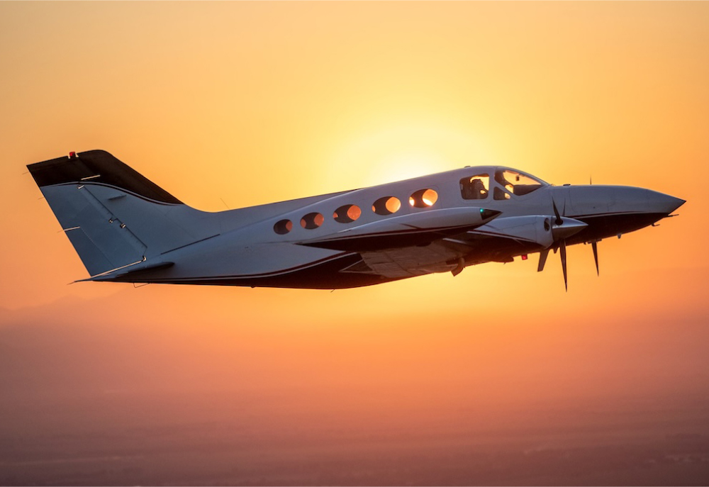 private aircraft flying against sunset