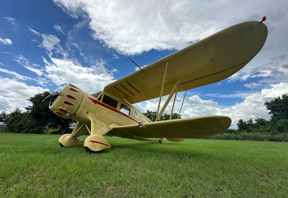 biplane on grass against blue sky