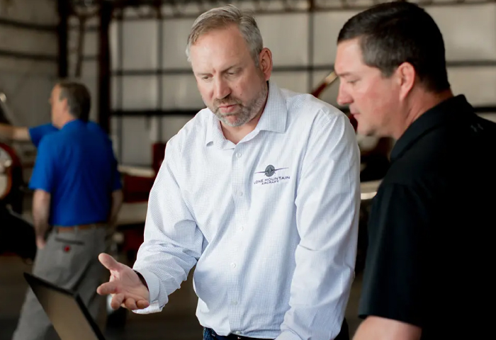 Customer and Lone Mountain staff discussing plane in hangar
