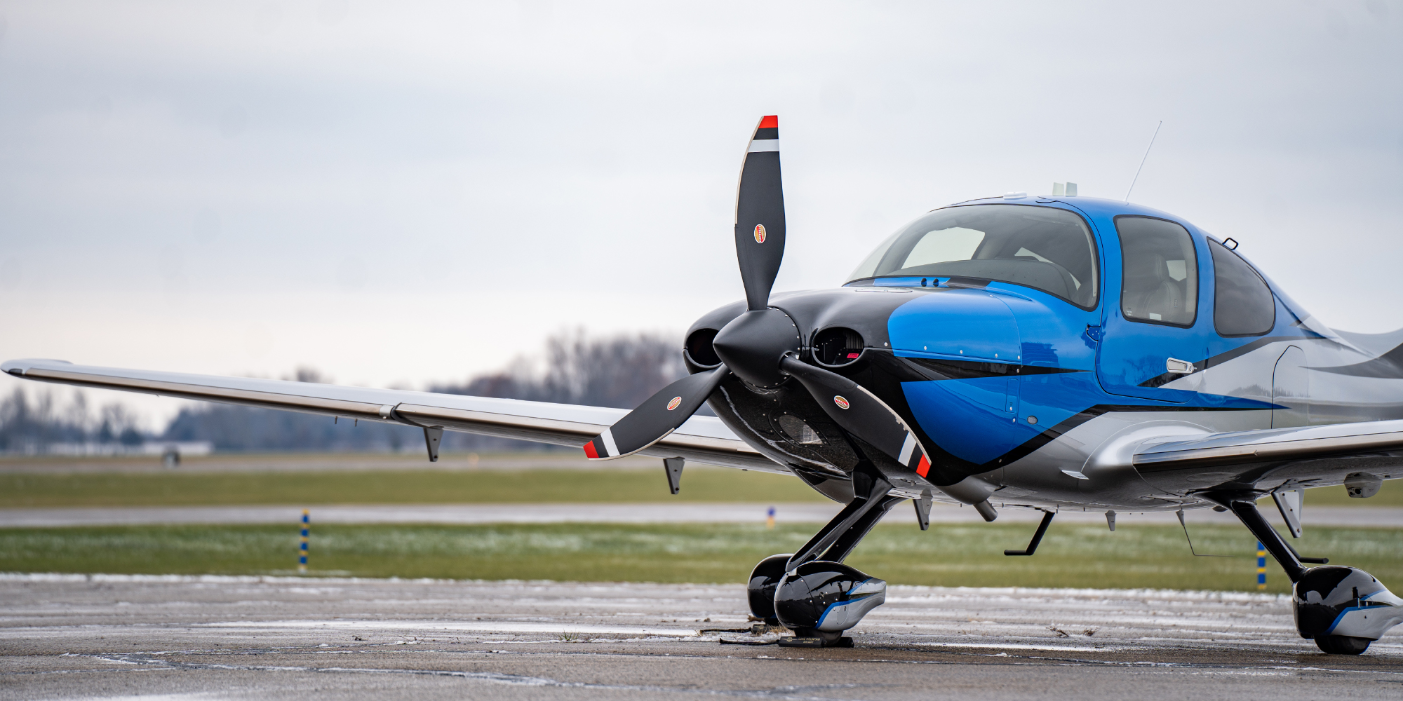 Blue private plane sitting on rainy tarmac