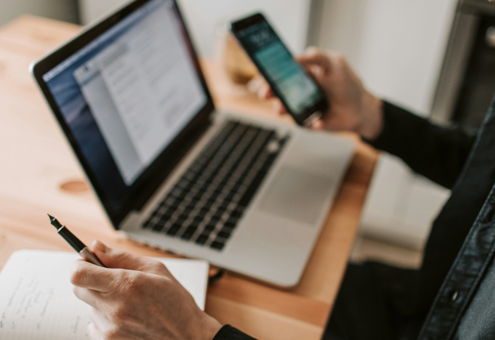 man using phone and laptop
