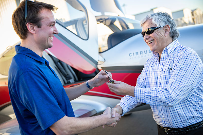Man handing over keys to plane to customer