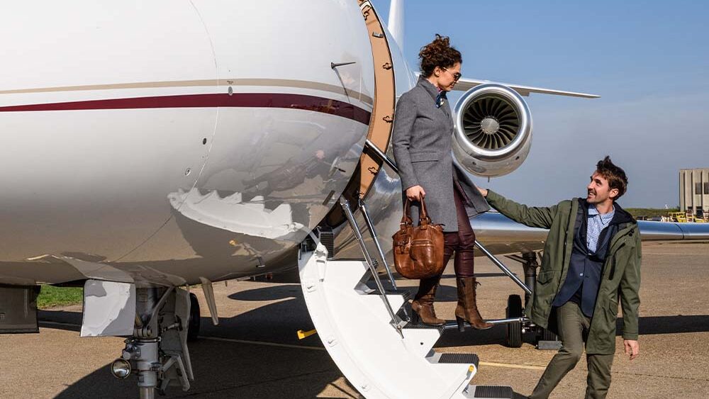 two people disembarking from private aircraft