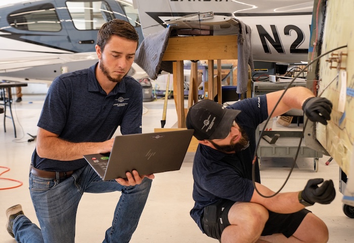 Lone Mountain Aircraft technicians reviewing maintenance on a Cirrus aircraft.