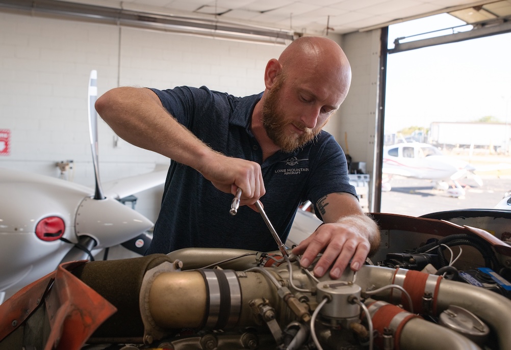 Lone Mountain Aircraft technician working on aircraft engine
